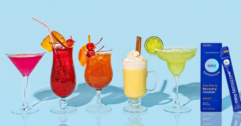 Five cocktails on a light blue background beside an Easy Tomorrow Mango jelly stick box.