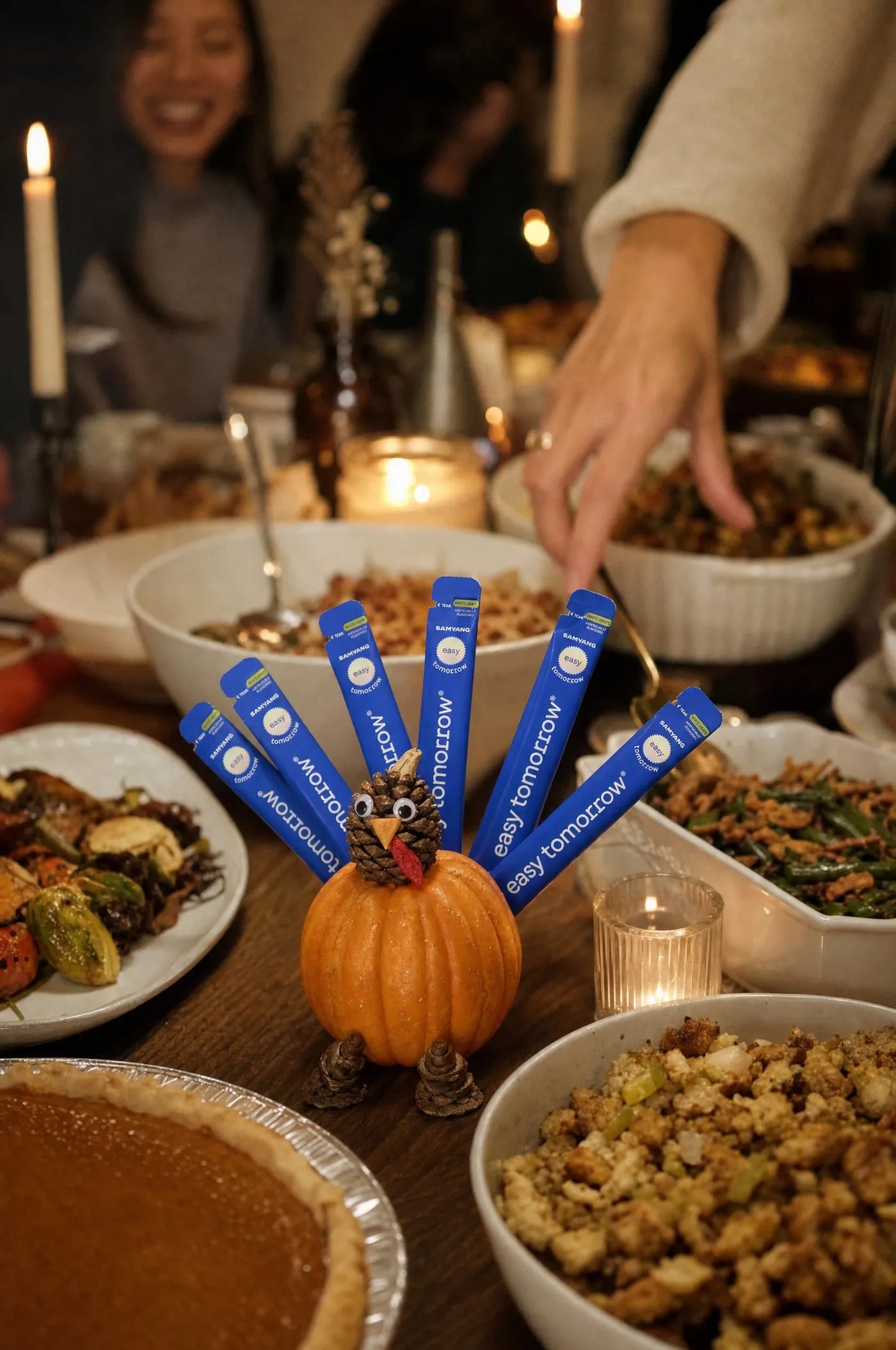 A pumpkin turkey centerpiece with Easy Tomorrow sticks as tail feathers on a Thanksgiving buffet